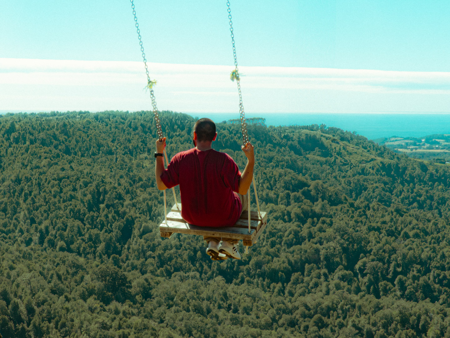 Suspendido sobre el bosque, el columpio ofrece una pausa improbable: un momento de vértigo y silencio donde la vista se pierde y el tiempo afloja.