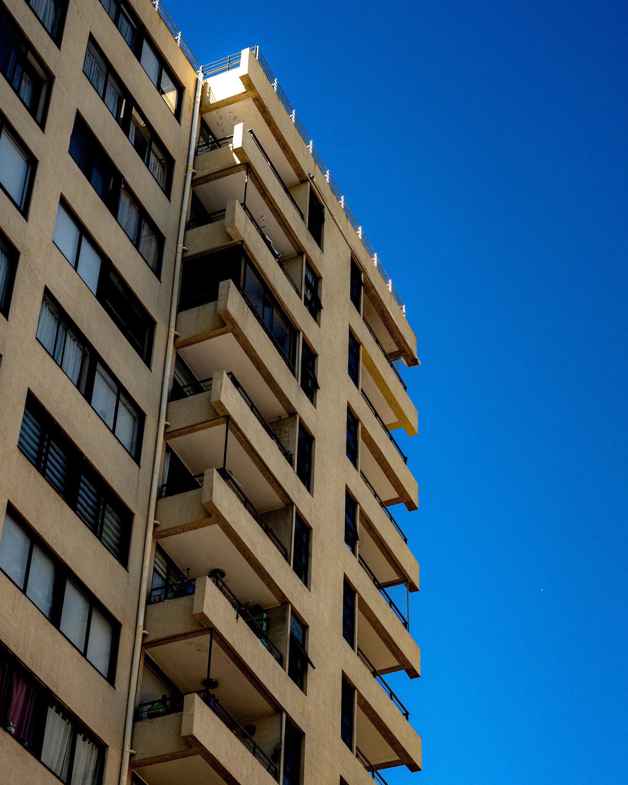 Un edificio de departamentos mirando de frente el cielo abierto, como si fuera otra pantalla más.