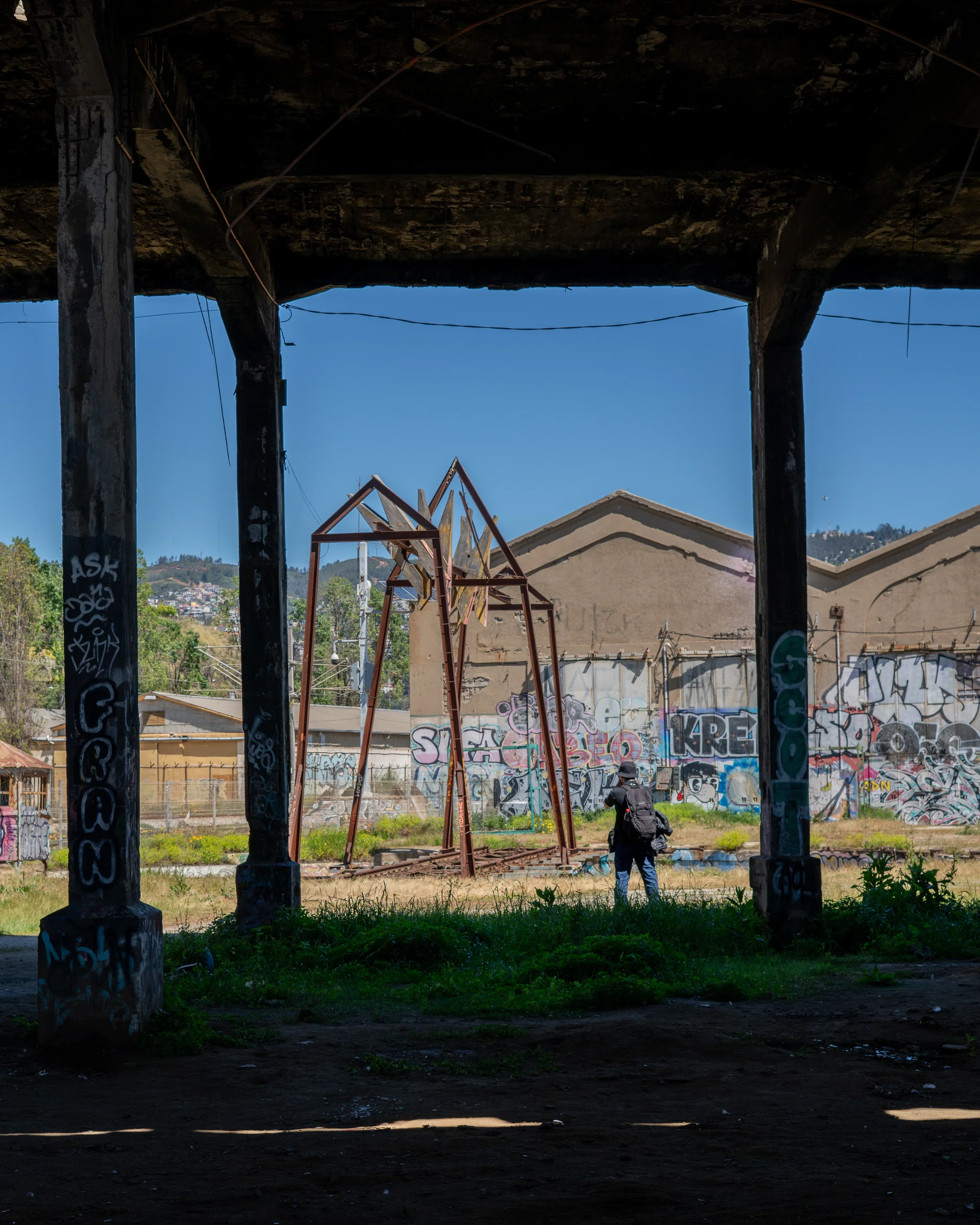 Un fotógrafo frente a estructuras metálicas oxidadas, registrando lo que antes fue industria y hoy es escenario.