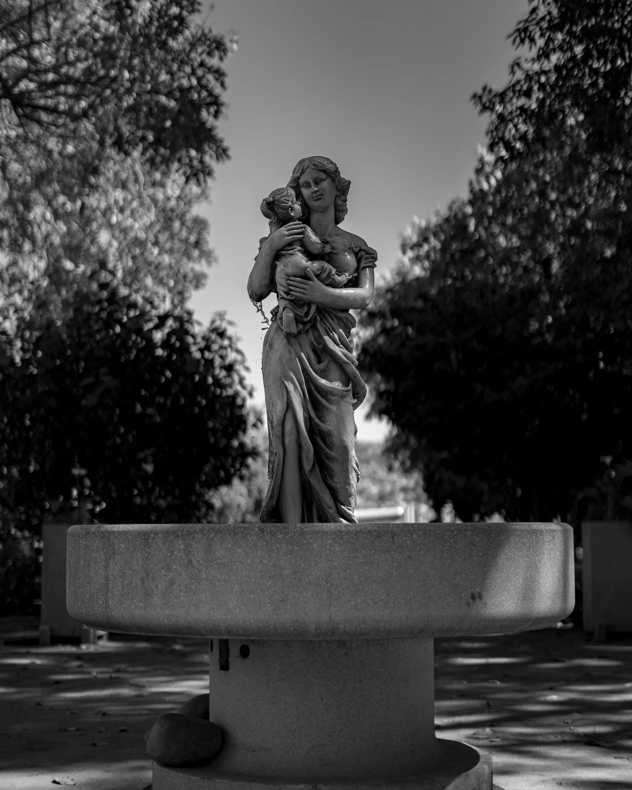 Una escultura en blanco y negro en medio de un jardín, detenida en un gesto eterno.